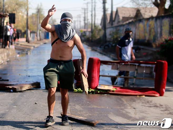중남미 칠레에서 코로나19 봉쇄가 길어지며 생활고가 가중되자 산티아고 외곽에 있는 빈민가 엘 보스케에서 18일(현지시간) 폭력 사태가 벌어졌다.© AFP=뉴스1