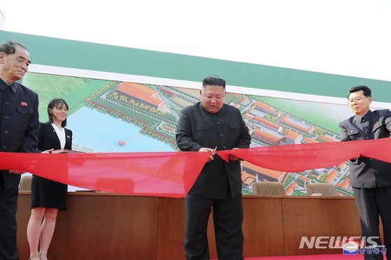 김정은 북한 국무위원장이 1일 평안남도 순천의 비료공장 준공식에 참석해 테이프를 자르고 있다. [뉴시스]