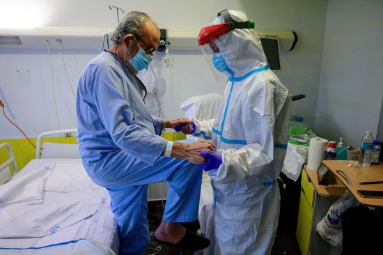 13일 마드리드 인근 푸에르타 데 히에로 대학병원에 한 물리치료사가 신종 코로나바이러스 감염증(코로나19) 환자의 회복을 돕고 있다. AFP연합뉴스