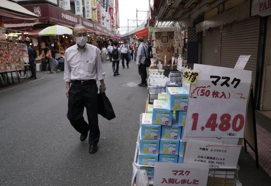 지난 25일 일본 도쿄 우에노공원 인근 아메요코 시장의 한 가게 앞에 마스크 상자가 쌓여 있다. 한 달새 마스크 가격은 절반 이하로 떨어졌다고 아사히신문은 27일 전했다. [EPA=연합뉴스]