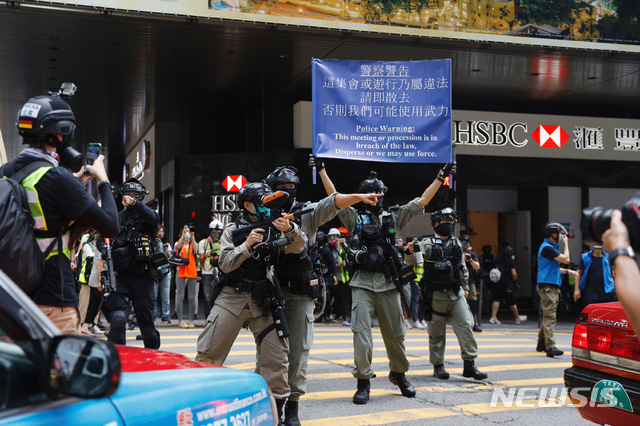 [홍콩=AP/뉴시스]27일 홍콩 입법부 앞에서 시위 진압 경찰이 시위대를 향한 경고문을 들고 시위대 해산을 시도하고 있다. 중국 전국인민대표대회(전인대)가 처벌 대상을 대폭 확대하는 홍콩 국가보안법 수정안을 추진하는 가운데 홍콩 시위대는 입법부 청사 밖에서 이에 반대하는 시위를 벌이고 있다. 2020.05.27.