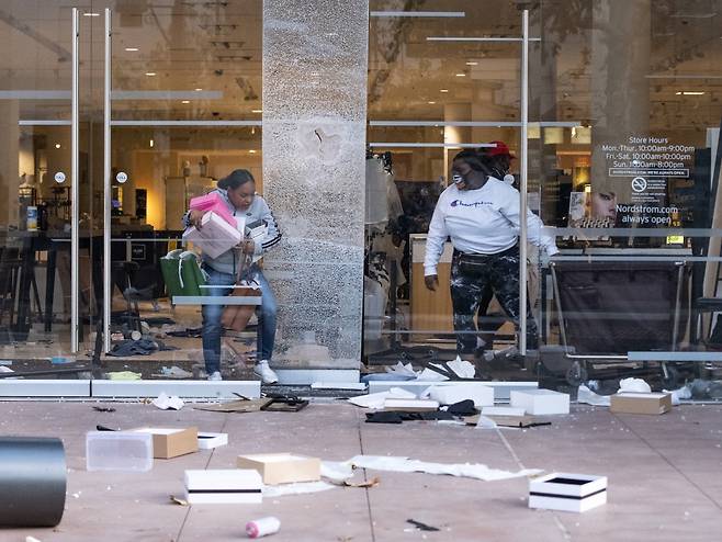 미국 로스엔젤레스 페어팩스 구역의 쇼핑센터에서 사람들이 물건을 훔쳐 나오고 있다. /사진=AFP