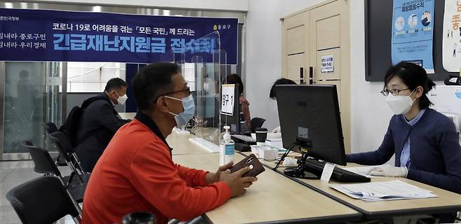 지난달 18일 서울 종로구의 한 주민센터에서 시민들이 긴급재난지원금 신청 접수를 하고 있다. 김혜윤 기자 unique@hani.co.kr