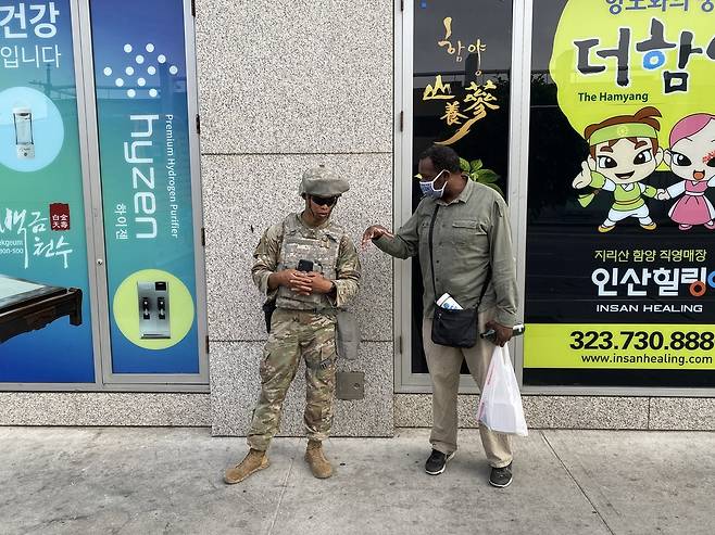 LA 한인타운 앞에서 대화를 나누는 중년의 흑인 남성과 주방위군 병사 (로스앤젤레스=연합뉴스) 정윤섭 특파원