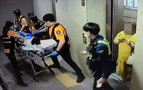 지난 1일 저녁 A군이 병원으로 옮겨지는 모습. 오른쪽 노란 옷이 B씨. [연합뉴스TV 캡처]