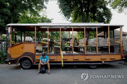 필리핀 마닐라의 관광버스 앞에 한 남성이 앉아 있다. (기사 내용과 상관없음) [로이터=연합뉴스]