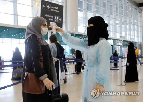 사우디아라비아 리야드 공항에서 국내선을 타는 승객의 체온을 재는 공항 직원 [로이터=연합뉴스자료사진]