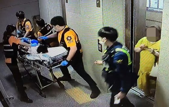 지난 1일 오후 9살 A군이 병원으로 옮겨지는 모습. 오른쪽 노란 옷이 계모 B씨. 연합뉴스