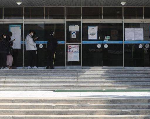 신종 코로나 바이러스 감염증(코로나19) 사태로 네 차례 미뤄진 398회 토익 시험이 치러진 지난 4월 26일 오전 서울 중구의 한 시험장에서 응시자들이 발열 체크 장소 앞에서 대기하고 있다. 연합뉴스