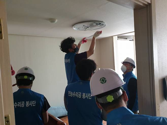 밀양시시설관리공단 만능수리공 봉사단이 내이동 장애인가정에서 전동리모컨을 설치하고 있는 모습. ©밀양