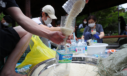 탈북단체 '큰샘' 회원들이 지난 18일 서울 강남구 일원동 일대에서 북한에 보낼 쌀을 페트병에 담고 있다. 뉴시스