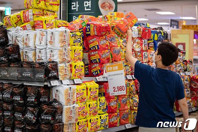 (서울=뉴스1) 유승관 기자 = 내달 1일부터 적용되는 '제품의 포장재질·포장방법에 관한 기준 등에 관한 규칙' 개정안을 두고 업계 혼선이 이어지고 있다. 환경부는 묶음 할인 판매가 금지되는 것 아니냐는 오해에 대해 해명자료를 내고 "묶음 포장에 가격 할인을 규제하려는 것이 아니라 끼워 팔기를 위한 불필요한 포장을 규제하는 것"이라고 밝혔다. 사진은 21일 서울시내 한 대형마트에서 묶음 포장 라면을 고르는 시민의 모습. 2020.6.21/뉴스1