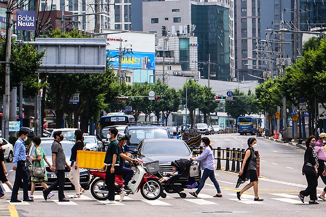 지난 23일 서울 동작구의 한 사거리에서 횡단보도를 건너는 유아차 앞을 오토바이가 지나가고 있다. 김재호 기자 ⓒ베이비뉴스