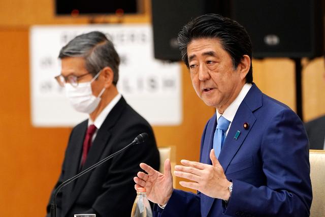 아베 신조(오른쪽) 일본 총리가 지난달 4일 도쿄 총리관저 기자회견에서 기자들의 질문에 답변하는 가운데 오미 시게루 전문가회의 부좌장이 마스크를 착용하고 동석해 있다. 도쿄=AP 연합뉴스