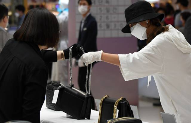 지난 26일 서울 롯데백화점 영등포점에서 열린 ‘면세 명품 대전’을 찾은 한 시민이 상품을 고르고 있다. 정부의 한시적 면세 상품 판매 허용 정책에 따라 기획된 이번 행사는 서울, 부산, 광주, 대전, 대구 등 전국 8개 지역에서 5일간 약 200억원 규모의 명품을 판매한다.
