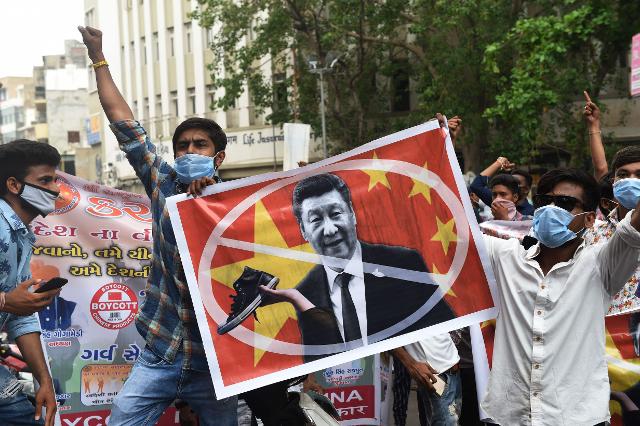 인도 서부 구자라트주 아마다바드에서 지난 24일 반중 시위대가 시진핑 중국 국가주석 사진에 불매운동 표시를 더한 현수막을 들고 있다. 아마다바드=AFP 연합뉴스