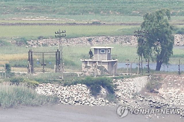 지난달 9일 북한 황해북도 개풍군 마을 철책을 지키는 북한 병사가 몸을 푸는 듯 한 발로 서있다. 연합뉴스