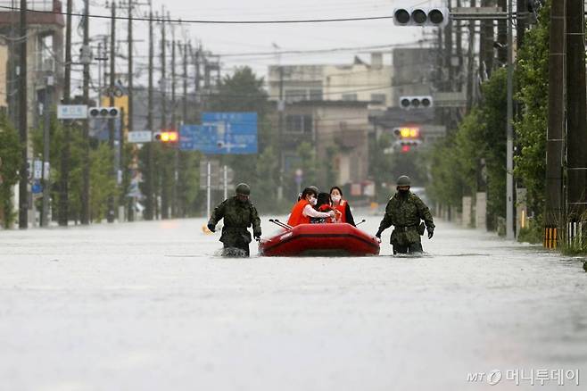 [후쿠오카=AP/뉴시스]7일 기록적인 폭우가 쏟아진 일본 규슈 지역 후쿠오카현 오무타무라에서 자위대원들이 고무보트를 통해 주민들을 구조하고 있다. 2020.07.07.