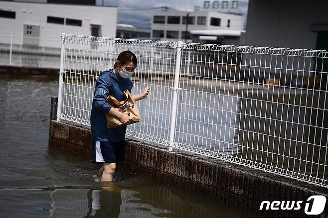 폭우 피해를 입은 일본에서 한 시민이 마스크를 쓰고 길을 가고 있다. (자료사진) © AFP=뉴스1
