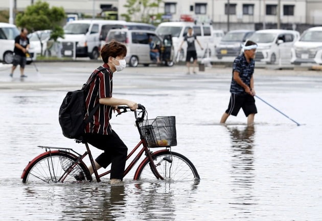 한 학생이 불어난 빗물을 가르며 자전거를 타는 모습 [사진=AP 연합뉴스]