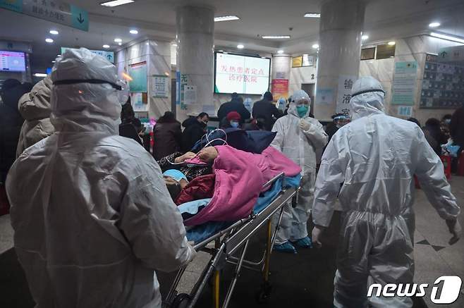 25일 중국 우한에 있는 우한 적십자병원에서 보호복을 입은 의료진이 신종코로나바이러스 의심환자를 황급히 병실로 옮기고 있다. © AFP=뉴스1 © News1 이종덕 기자