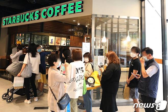(서울=뉴스1) 황기선 기자 = 28일 서울 노원구 이마트타운 월계점 스타벅스 매장에서 고객들이 '서머e-프리퀀시' 이벤트를 위해 줄을 서 있다. 지난 21일 '세머e프리퀀시' 이벤트를 시작한 스타벅스는 증정품으로 캠핑용 의자와 여행 가방을 선보였다. 2020.5.28/뉴스1