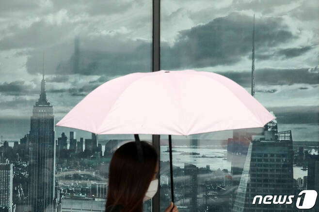 수도권 지역에 비가 내린 13일 오후 경기도 수원시내 거리에서 한 시민이 우산을 쓴 채 걷고 있다. 2020.7.13/뉴스1 © News1 조태형 기자