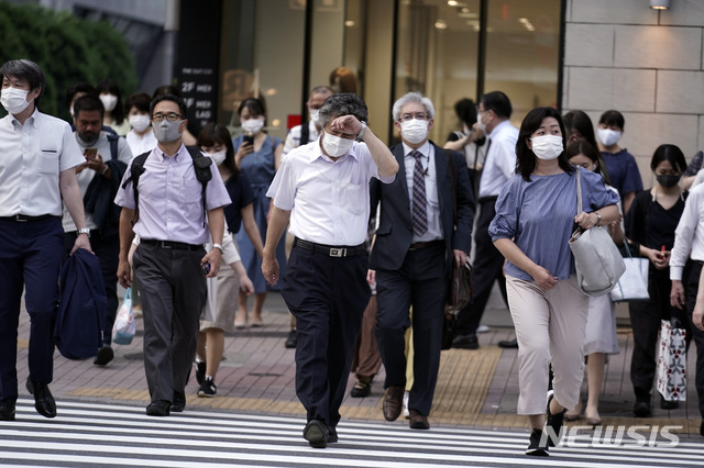 [도쿄=AP/뉴시스]지난 20일 일본 도쿄의 한 횡단보도를 신종 코로나바이러스 감염증(코로나19) 예방을 위해 마스크를 쓴 시민들이 건너고 있다. 2020.07.21.