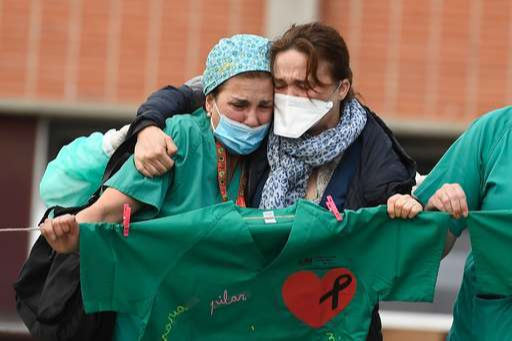 지난 4월 스페인 레가네스의 한 병원 앞에서 의료 종사자들이 코로나19 대응 도중 사망한 동료 간호사의 죽음을 슬퍼하고 있다. 레가네스=AFP연합뉴스