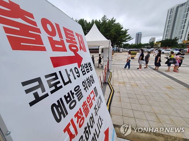 방역수칙 지켜요 (속초=연합뉴스) 이종건 기자 = 26일 속초해수욕장을 찾은 피서객들이 마스크를 착용한 채 소독기가 설치된 지정 게이트를 통해 백사장으로 들어가고 있다. 2020.7.26 momo@yna.co.kr