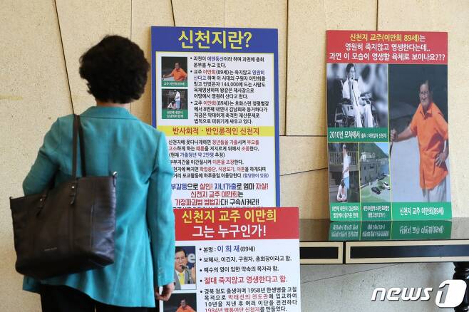 지난달 30일 서울 영등포구 여의도 CCMM빌딩에서 열린 신천지·동방번개 대책 기자회견에서 한 참석자가 신천지 관련 피켓을 보고 있다./사진=뉴스1DB
