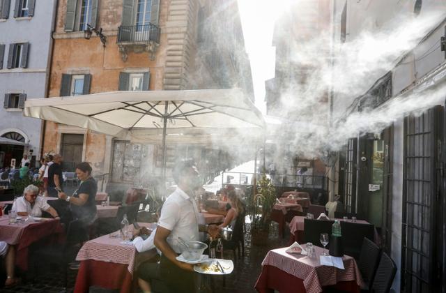 이탈리아 로마에서 지난달 31일 34도가 웃도는 무더운 날씨를 보이고 있는 가운데 한 카페 에서 손님들의 열기를 식혀주기 위해 물을 분무하고 있다. 로마=AP 연합뉴스