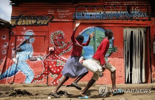 지난 6월 3일 케냐 나이로비에서 '코로나19 주의' 벽화 앞을 달려가고 있다. [AP=연합뉴스 자료사진]