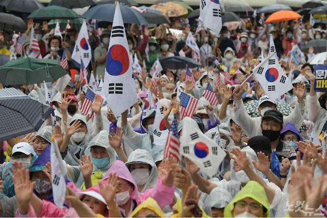 지난 15일 오후 서울 종로구 동화면세점 앞에서 열린 보수단체의 광복절 집회에서 참석자들이 태극기와 성조기를 흔들고 있다.(사진=이한형 기자)