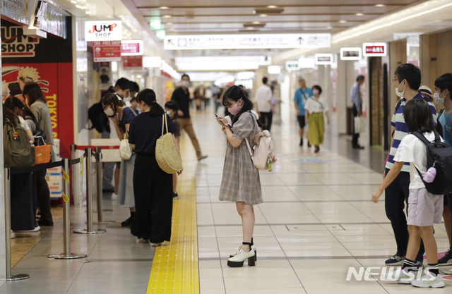 [도쿄=AP/뉴시스] 일본 도쿄의 한 상점 앞에 마스크를 착용한 시민들이 줄을 서있다. 2020.08.22