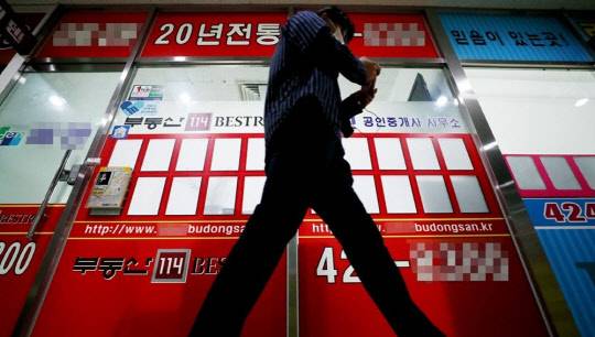 한 시민이 서울 송파구 아파트 단지 상가의 부동산 중개업소 앞을 지나가고 있다.
연합뉴스