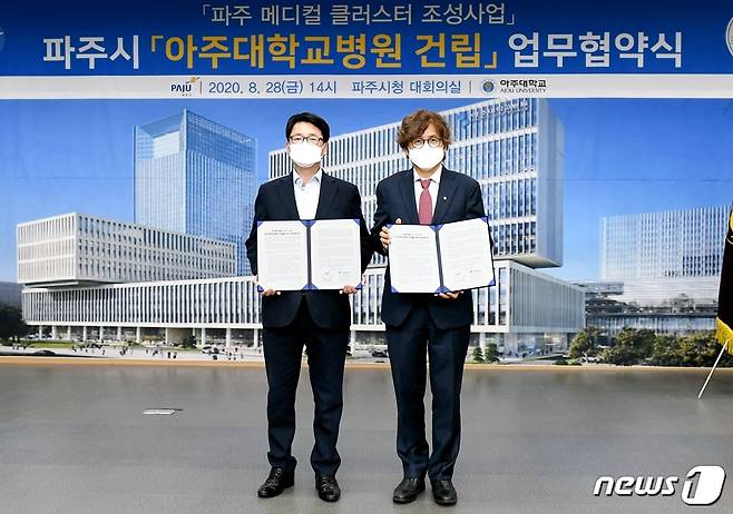 28일 파주시청 대회의실에서 최종환 파주시장(왼쪽)과 박형주 아주대학교 총장이 '아주대학교병원 건립 업무협약서'에 서명한 뒤 기념촬영을 하고 있다.(파주시청 제공) © 뉴스1