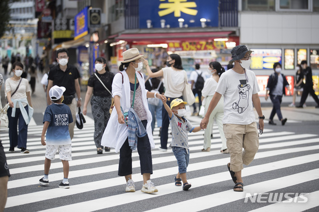 [도쿄=AP/뉴시스]지난 17일 일본 도쿄 신주쿠의 한 횡단보도를 마스크를 쓴 가족이 건너고 있다. 2020.08.20.