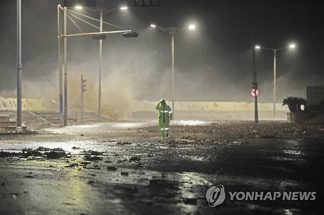 제주 탑동 방파제 월파 (제주=연합뉴스) 박지호 기자 = 태풍 마이삭이 퍼부은 폭우에 만조 현상까지 겹쳐 2일 밤 제주시 탑동 방파제를 넘어 월파 현상이 계속돼 인근 저지대 주택이 침수됐다. 3일 새벽 한 경찰관이 저지대의 차량통행 제한하기 위해 순찰을 하고 있다. 2020.9.3 jihopark@yna.co.kr