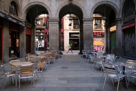 지난달 7일 스페인 바르셀로나에서 마스크를 쓴 시민이 텅 빈 야외 식당을 지나고 있다.로이터뉴스1