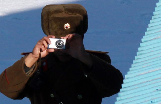 2014년 12월 18일 최윤희 합참의장이경기도 파주 판문점 내 '자유의 집'을 방문하자, 북한군 경비대원이 카메라로 남측을 촬영하고 있다. 2000년도에 유행한 캐논사의 똑딱이 카메라. 사진공동취재단