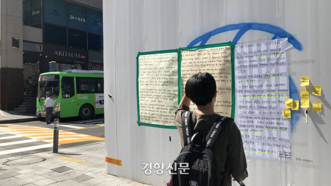 20일 오후 서울 마포구 홍대입구역 앞 도로에서 한 시민이 발걸음을 멈추고 대자보를 읽고 있다. 조해람 기자