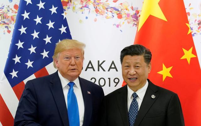 지난해 일본 오사카에서 열린 G20 정상회의에서 도널드 트럼프(왼쪽) 미국 대통령과 시진핑 중국 국가 주석이 사진촬영을 하고 있다. 로이터 연합뉴스