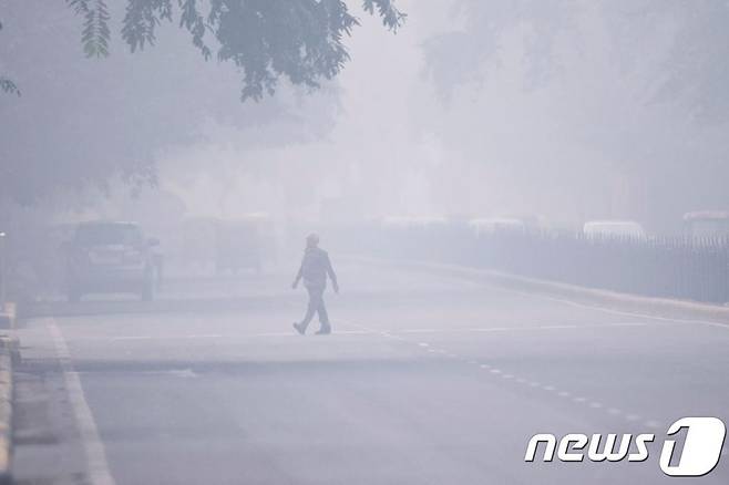 (AFP=뉴스1) 지난해 11월 4일 (현지시간) 스모그가 짙은 인도 수도 뉴델리에서 한 남성이 길을 건너고 있다. 사진은 기사와 직접적인 관련이 없음. ⓒ AFP=뉴스1