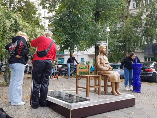 지난 25일(현지시간) 독일 베를린에 세워진 평화의 소녀상의 비문을 보는 시민과 소녀상 옆 식수대에서 물을 마시는 시민./베를린연합뉴스
