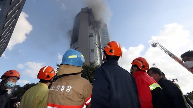 소방당국자들이 9일 울산 33층 주상복합아파트 화재현장을 지켜보고 있다. 사진=연합뉴스