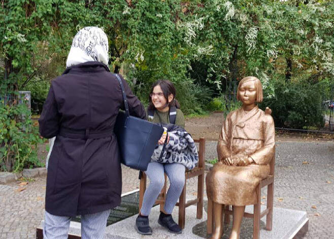 지난 9월 25일(현지시간) 독일 수도 베를린에 설치된 ‘평화의 소녀상’ 옆에 한 소녀가 앉아있다. (사진=연합뉴스)