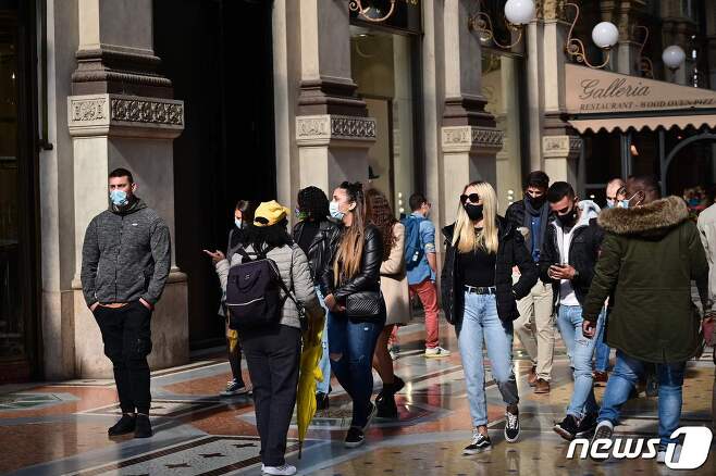 17일(현지시간) 이탈리아 밀라노에서 마스크를 쓰고 거리를 걷는 사람들. © AFP=뉴스1