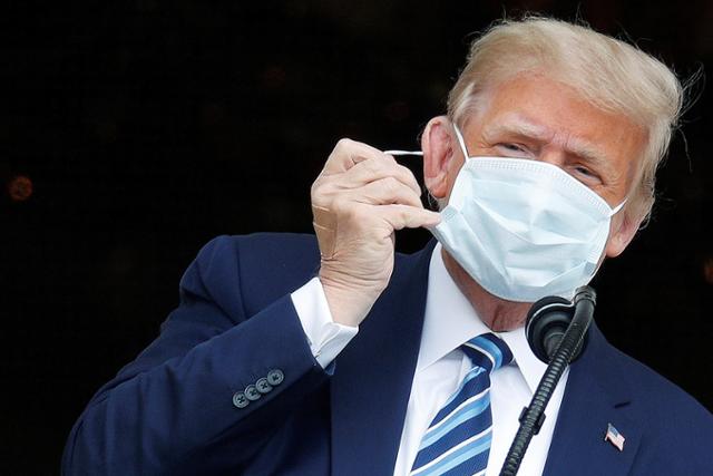 코로나19에 걸려 입원 치료를 받았던 도널드 트럼프 미국 대통령이 10일 백악관에서 퇴원 후 첫 공개행사를 열고 블루룸 발코니에 등장해 마스크를 벗고 있다. 워싱턴=로이터 연합뉴스