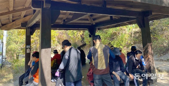 18일 서울 북한산 국립공원의 한 쉼터에서 등산객 10여 명이 마스크를 턱에 걸치거나 쓰지 않은 채 모여 있다. 유채연 인턴기자 연세대 철학과 4학년